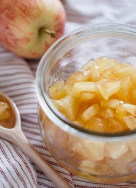 two apples, apple jam in a jar and a spoon