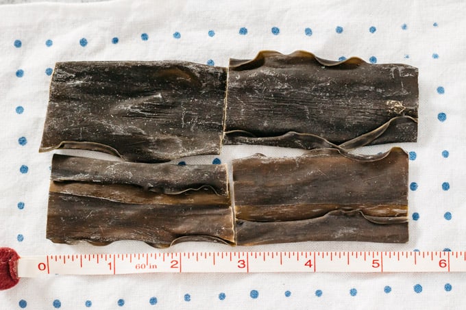 4 pieces of Kombu kelp with measuring tape showing length about 5.5 inches