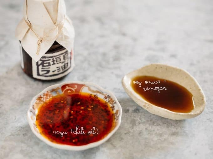 a small bowl of rayu chili oil "rayu" and a small bowl of soy sauce and rice vinegar