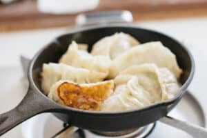 6 gyoza dumplings in a cast iron skillet