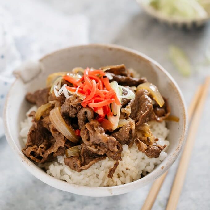 Gyudon served in a large Japanese rice bowl topped with red pickled ginger 