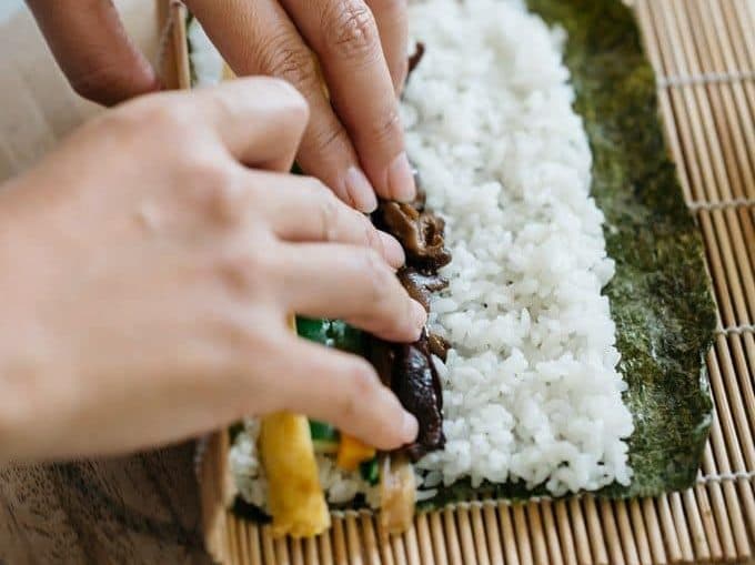 rolling a sushi with a bamboo sushi rolling mat