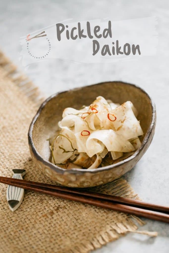 Tsukemono, pickled daikon served in an oval shallow bowl with a pair of chopstick