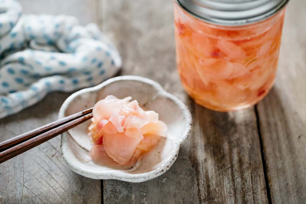 pickled ginger served on a small plate and a jar of pickled ginger