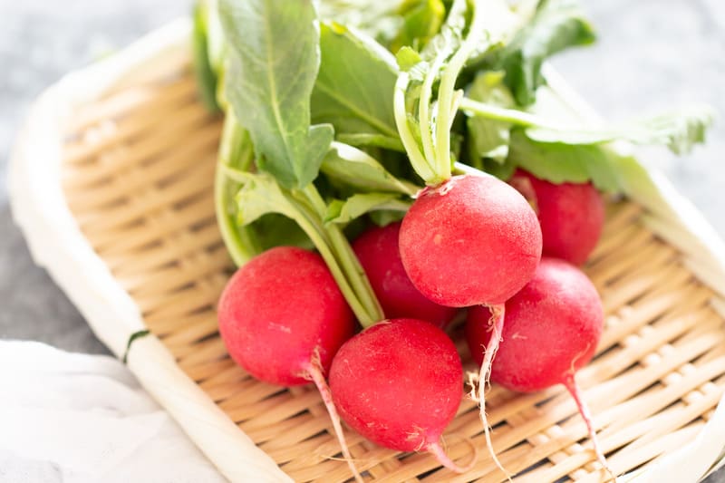 a bunch of radish on a bamboo tray