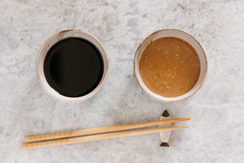Sweet Soy sauce (left) and sesame (right) dipping sauce in small bowls 