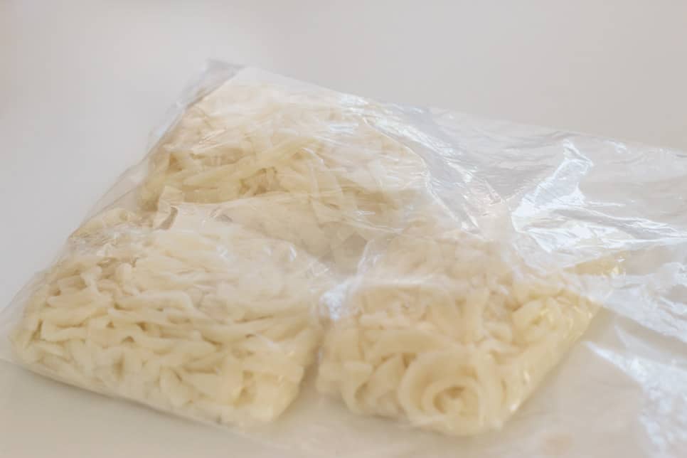 Three portions of udon noodles wrapped and in a ziplock bag