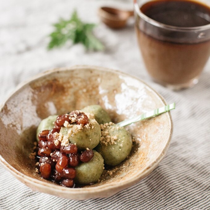 Yomogi dango served in a Japanese pottery bowl with azuki bean paste and kinako powder with iced coffee