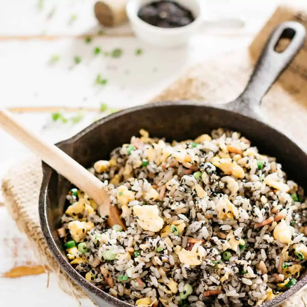 Black sesame fried rice cooked in a cast iron frying pan 