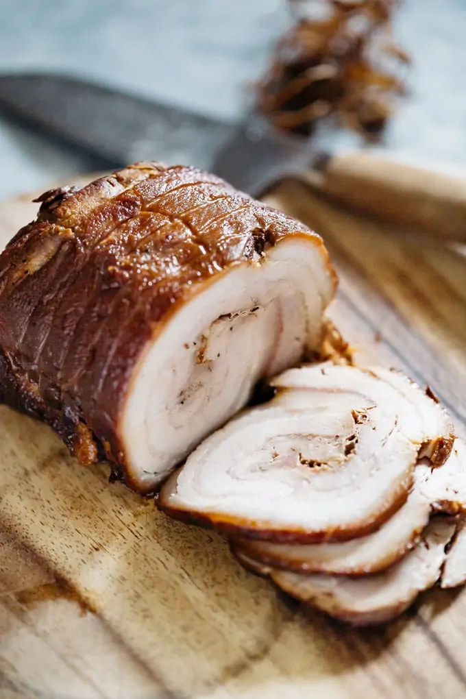 Chashu being sliced on a chopping board