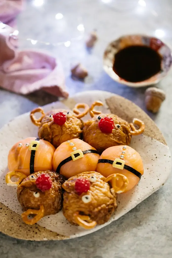 four reindeer rice balls and santa rice balls on a plate