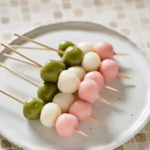 6 hanami dango on skewers on a round plate