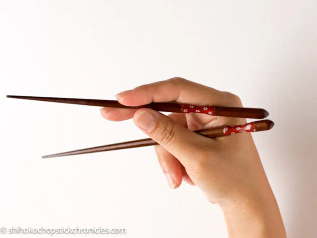 two chopsticks parallel to each other in a hand