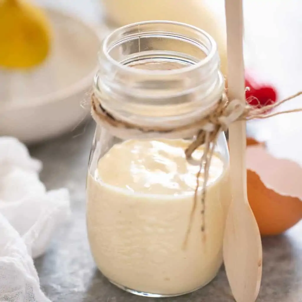 Japanese mayo in a small glass jar with wooden spoon