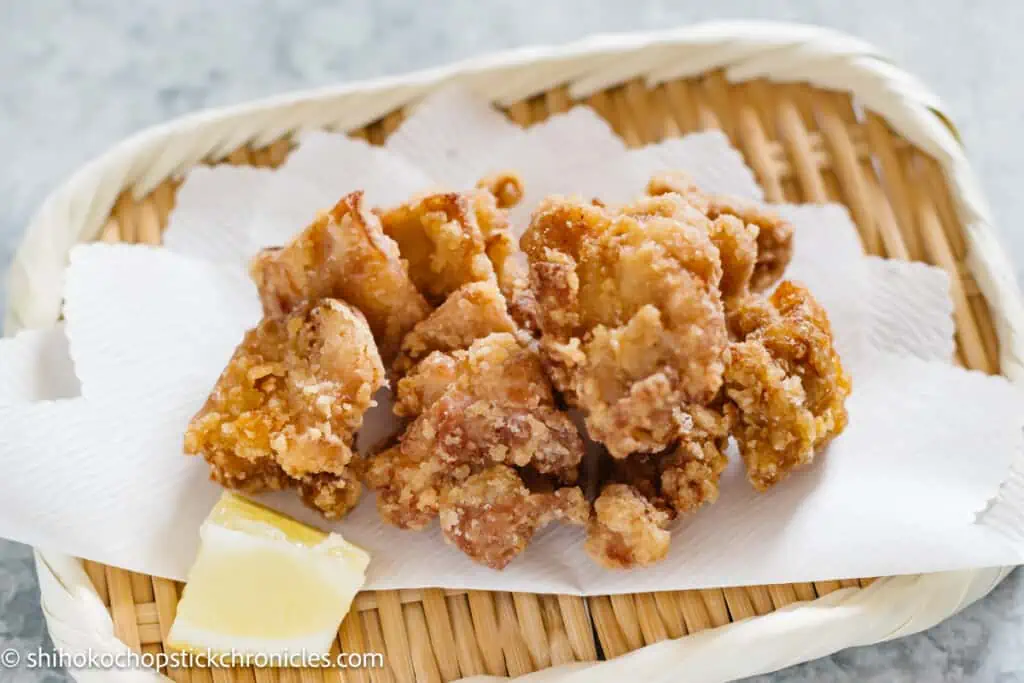 karaage chicken served on rectangle bamboo tray with a wedge of lemon