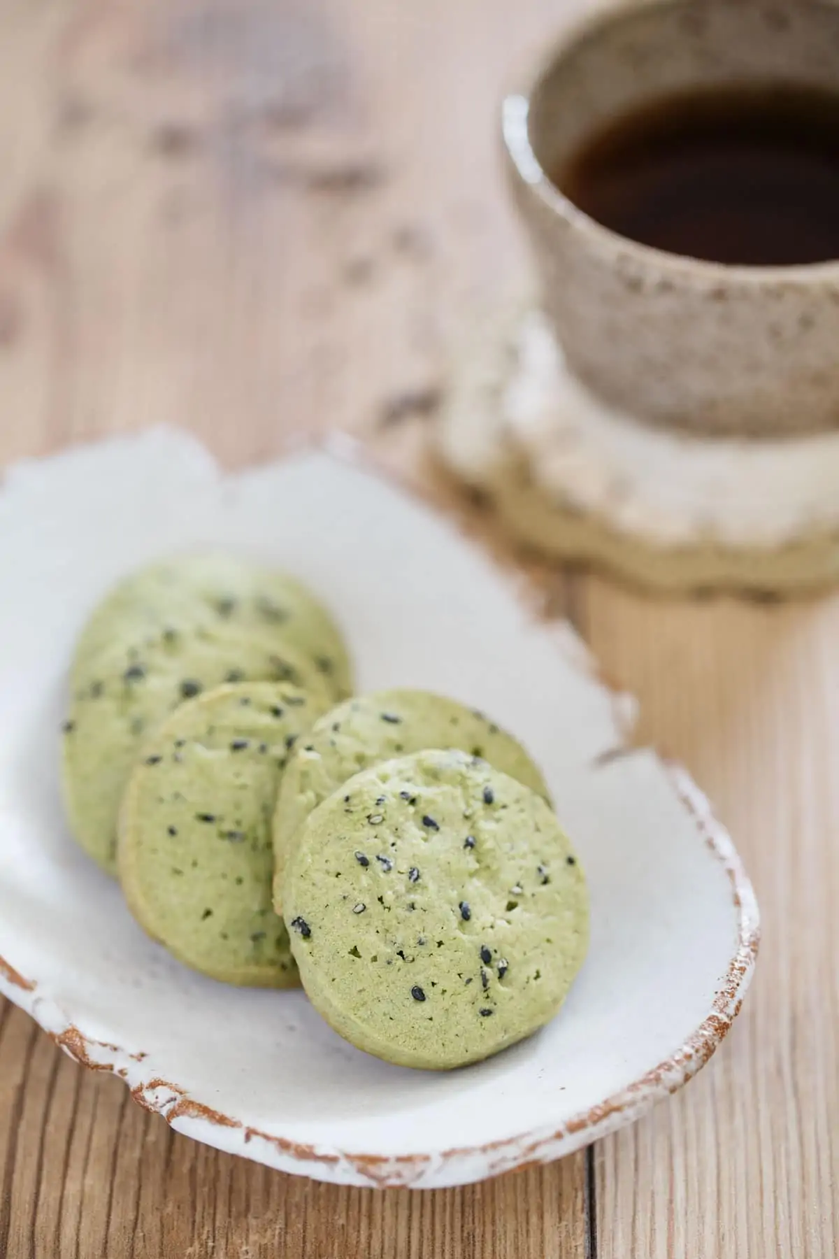 Matcha and black sesame seeds cookies on an oval plate with tea