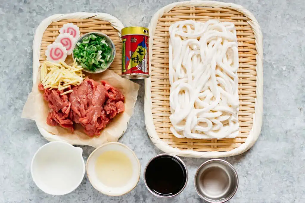 udon noodles, thinly sliced beef, finely chopped scallions, slices of naruto, soy sauce, sugar, mirin and sake