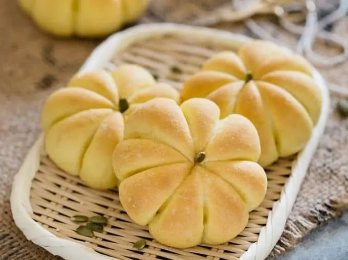 3 Kabocha pumpkin shaped bread rolls on a bamboo tray