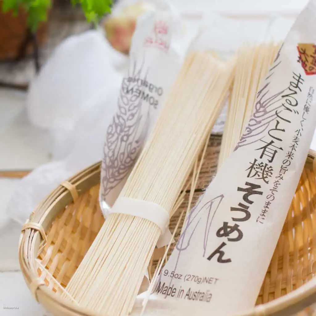 dry somen noodles one bundle outside and a packet on a bamboo tray